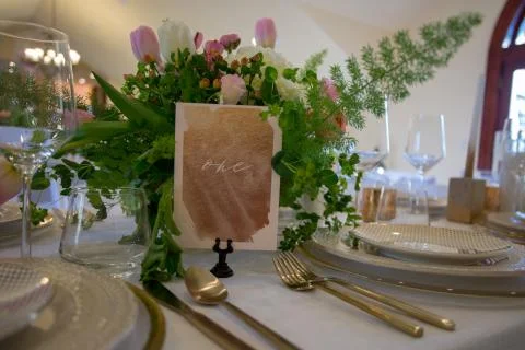 Close up of wedding table set decorated with fresh flowers. Stock Photos