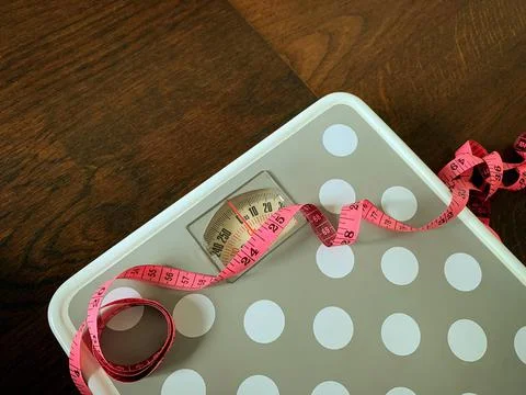 Close up of a weight scale and measuring soft tape . Fitness and weight loss Foto stock