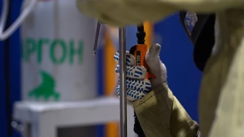 Close-up welder man connects two iron parts on factory background. Light flashes Stock Footage 126357992