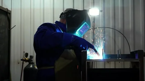 Close-up of welder welds parts using semi-automatic welding machine. Stock Footage 246502198