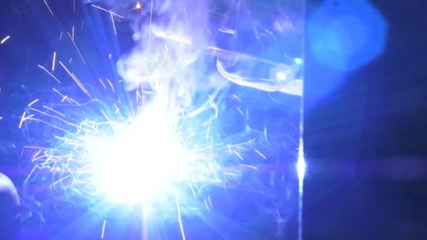 Close-up welder works with electrode in protective helmet and glows Stock Footage 288709826