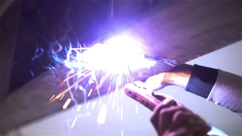 Close up welding machine with sparks and flashes by construction worker Stock Footage 138330778