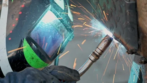 Close-up of welding process with visible sparks and protective gear in worksh Stock Footage 284244520
