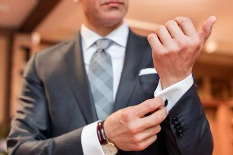Close up well-dressed businessman adjusting cufflinks Stock Photos