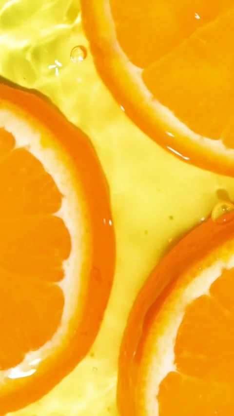 Close-up of wet orange fruit pattern in liquid with waves, commercial footage Stock Footage 340168083
