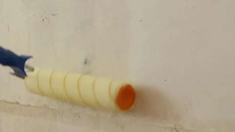 Close up of wet paint roller coating wall surface with primer Stock Footage 340404011