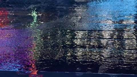 Close up of Wet pavement Texture with Neon Light Reflections at Night under the Vídeo Stock 343328262