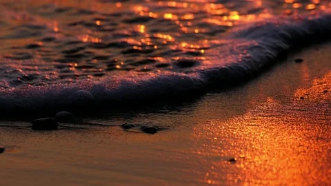 Close up from Wet sand on sunset, waves and reflection from the sun Stock Footage 169145645