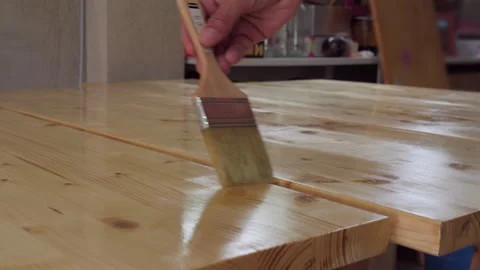 Close up of wet shiny varnish being applied to wooden table Stock Footage 335679855