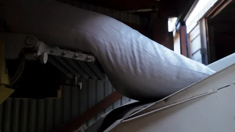 Close-up wheat bag falls on conveyor belt from rotate conveyor rollers 库存影片 98102368