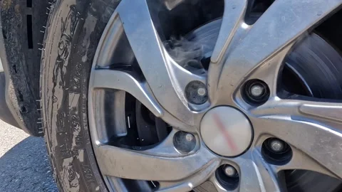 Close-up of the wheel brake pads caught on fire and are smoking Stock-Footage 317387280