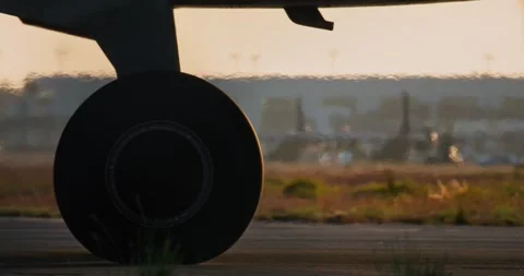 A close-up of the wheels of an airplane going to the runway at sunset. Vídeos de archivo 294708638