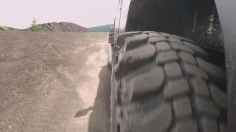 Close-up of the wheels of an SUV driving on a dusty road during a mountain Stock Footage 231468593