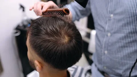 Close-up in which the barber dries a customer's hair. Stock-Footage 144291518