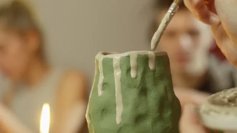 Close-up on which paint is added to a craft product made of clay. Vídeo Stock 247248963