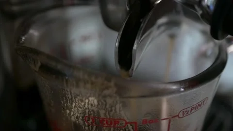 Close up while shot of Espresso Pouring from both Sides of an Espresso Make.. Video stock 259788932