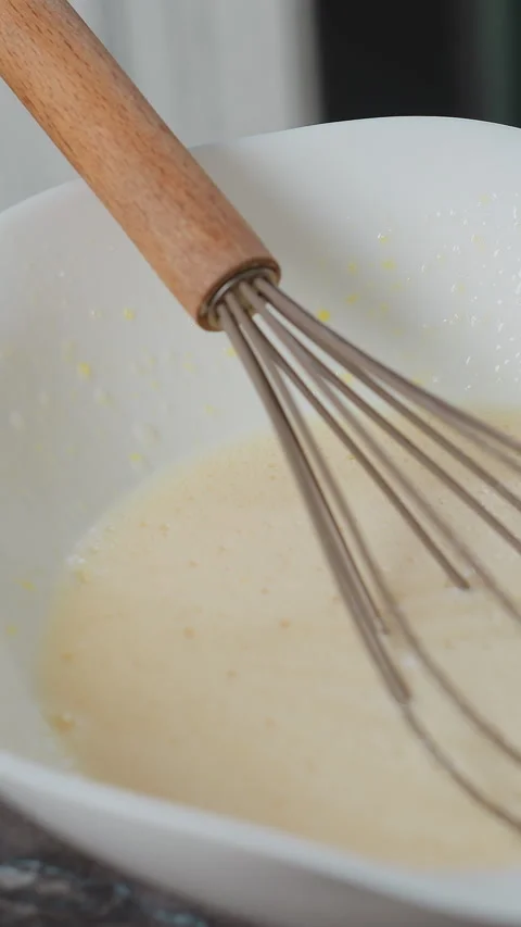 Close-Up of Whisk Resting in Baking Mixture on Kitchen Countertop Stock Footage 320338413