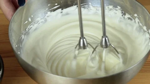 Close up: Whisks whipped egg whites and sugar in the bowl of glass. Whisk in Vídeo Stock 74803403