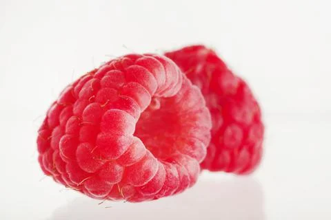 Close-up. On a white background, two appetizing red raspberries. Useful vitam Stock Photos