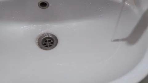 Close-Up Of White Bathroom Sink With Drain And Wet Surface For Clean, Modern Video stock 325097722