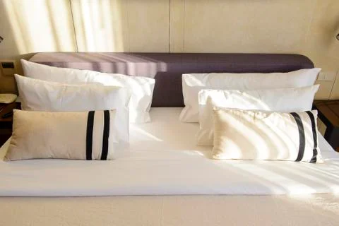Close up white bedding sheets and pillow in hotel room Stock Photos