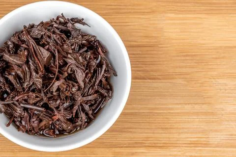 Close-up on a white bowl with used tea leaves. Stock Photos