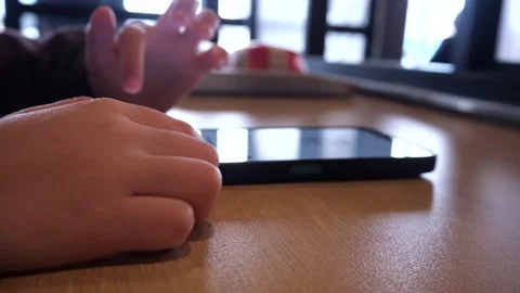 Close-up of a white boy's hands, aged 3-5, scrolling through his phone Stock Footage 306087113