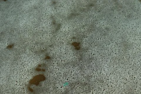 Close-up of white bubble from water wave on beach Stock Photos
