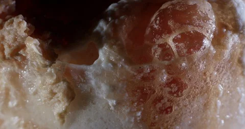 Close up of white bursting bubbles, macro  shot of pink foam in a glass, 4k Stock Footage 107350015