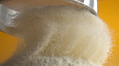 Close up of  white cake flour falling through a metal sieve in slow motion Stock Footage 64872340