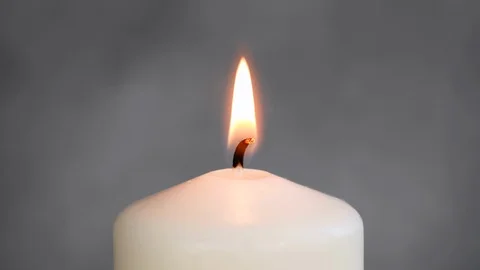 Close-up white candle light. White candle Fire Wick dancing at gray background Stock Footage 127283687