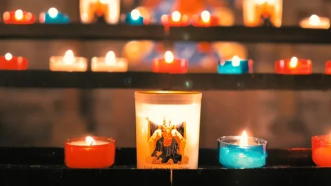 Close-up of white candles with icon and unfocused background of colored candles Stock Footage 124474367