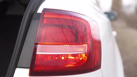 Close-up of a white car headlight with a flashing turn signal. The car alarm is Stock Footage 264094713