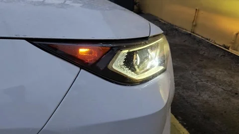 Close-up of white car LED low beam headlight turned on Stock Footage 327067291