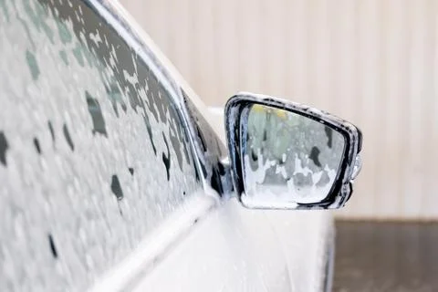 Close-up of white car side mirror covered in washing foam Stock Photos