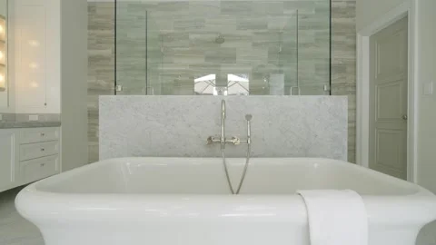 Close up white ceramic bath tub with towel hanging on side standing in middle of Stock-Footage 282256487