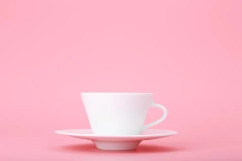 Close up of white ceramic coffee or tea cup isolated on bright pink background Stock Photos