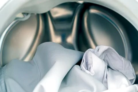 Close up white clothes in washing machine background. Laundry concept. Stock Photos