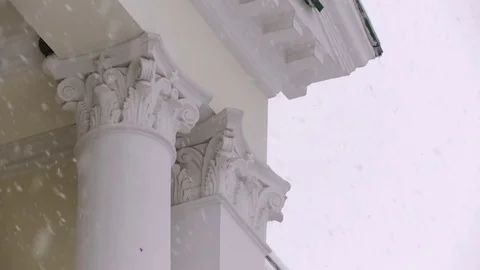 Close-up of white columns of a large building in the winter in a snowfall Stock Footage 82674535
