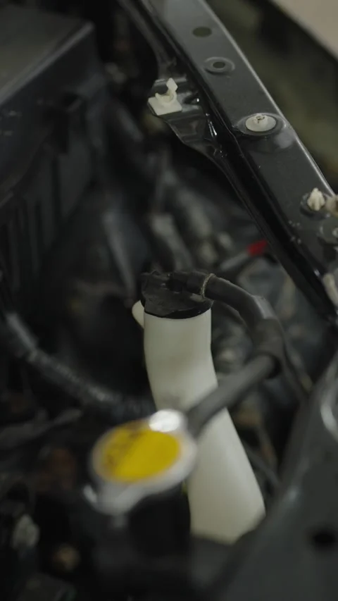 Close-up of white coolant overflow tank next to radiator cap Stock Footage 340273490
