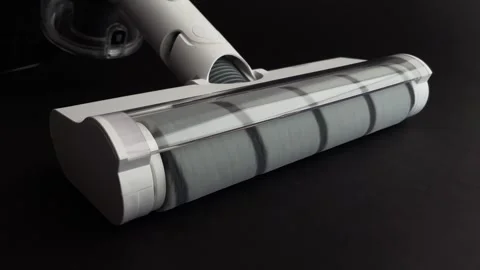 Close-up of a white cordless vacuum cleaner nozzle on a black background. The br Stock Footage 340194581