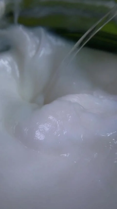 Close up of white cream being stirred using a transparent spoon. Smooth mix.. Stock Footage 340329370
