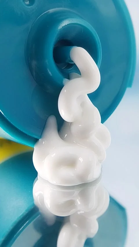 Close up of white cream slowly dispensing from turquoise packaging, skincare Stock Footage 331294341