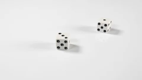 Close up of a white double dice thrown onto a white surface background Stock Footage 89187516