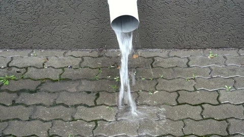 Close-up of a white drainpipe on the facade of the building, from which a stream Video stock 118514935