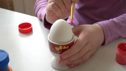 Close-up, white Easter egg stands on a stand, and the child draws on it with a Video stock 103090490