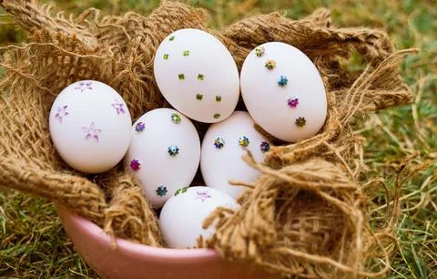 A close-up of white Easter eggs adorned with colorful sequins and arranged .. Foto stock