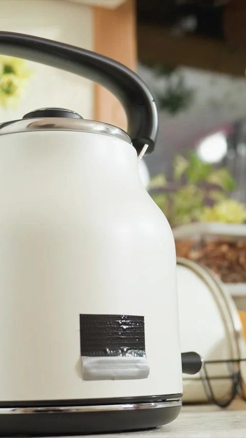 Close up of white electric kettle with black accents on kitchen countertop Stock Footage 344419902