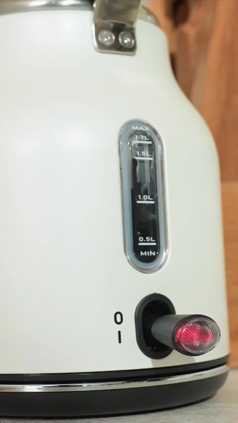 Close up of white electric kettle with illuminated red indicator and water level Vidéo 344422877