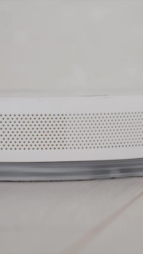 Close up of white electronic device with perforated speaker grille on wooden Stock Footage 346786423